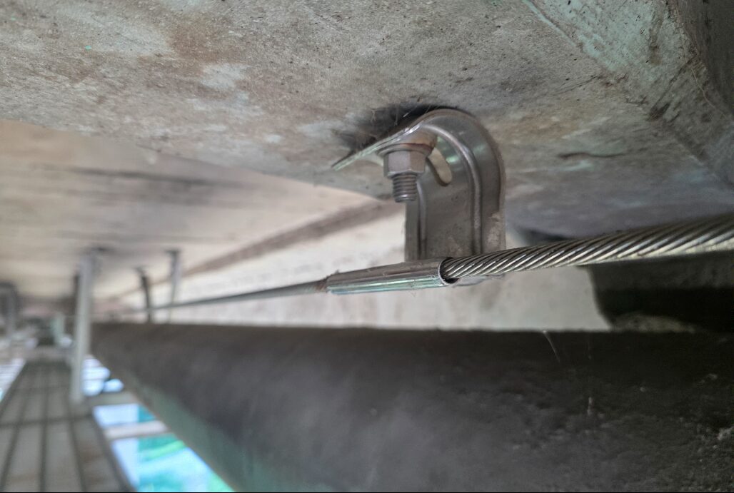 Stainless steel cable and anchor system installed beneath a concrete bridge deck by SkyHigh Safety Solutions