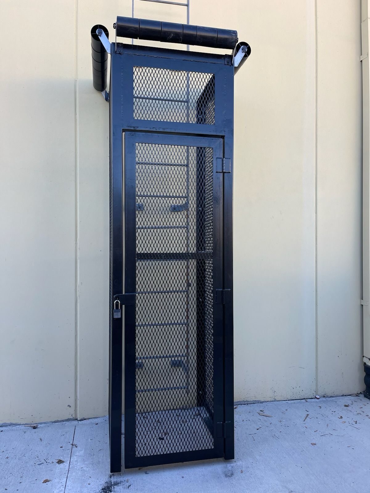 Custom-fabricated fixed vertical ladder with walk-through rails and standoff brackets on an industrial structure