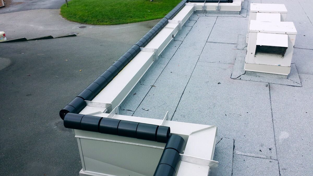 Perimeter anti-climb roller barrier system installed around a commercial flat roof by SkyHigh Safety Solutions