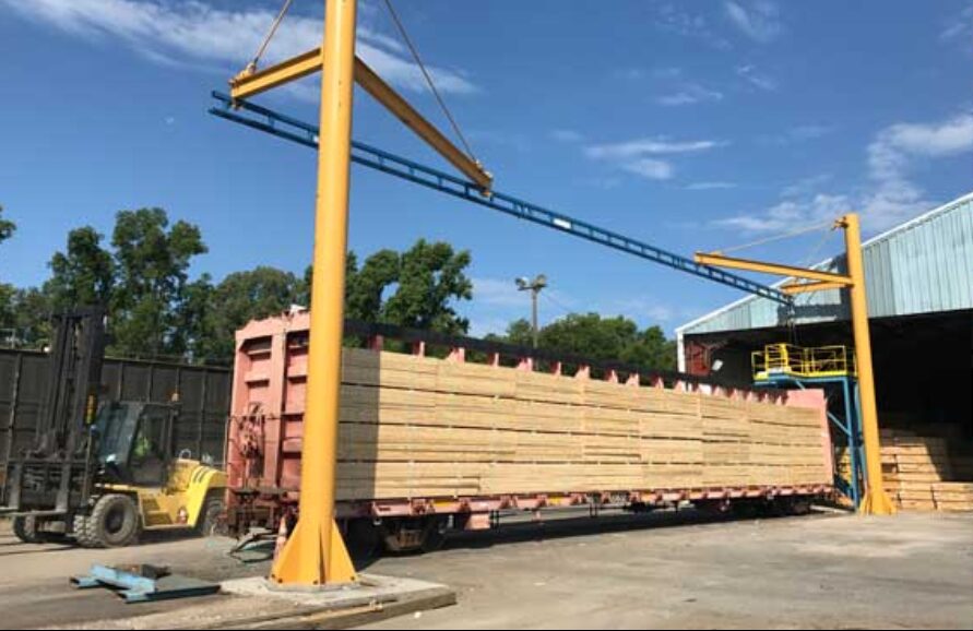 SkyHigh gantry crane rigging and lifting structural material at an industrial yard