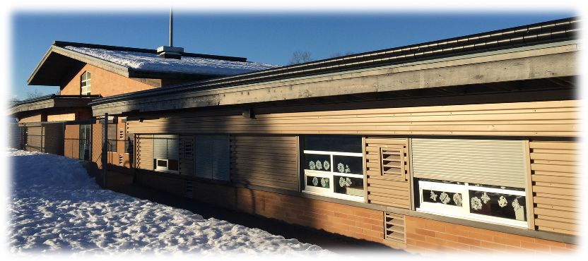 Climb-prevention roller barriers installed on a school rooftop parapet to deter unauthorized access